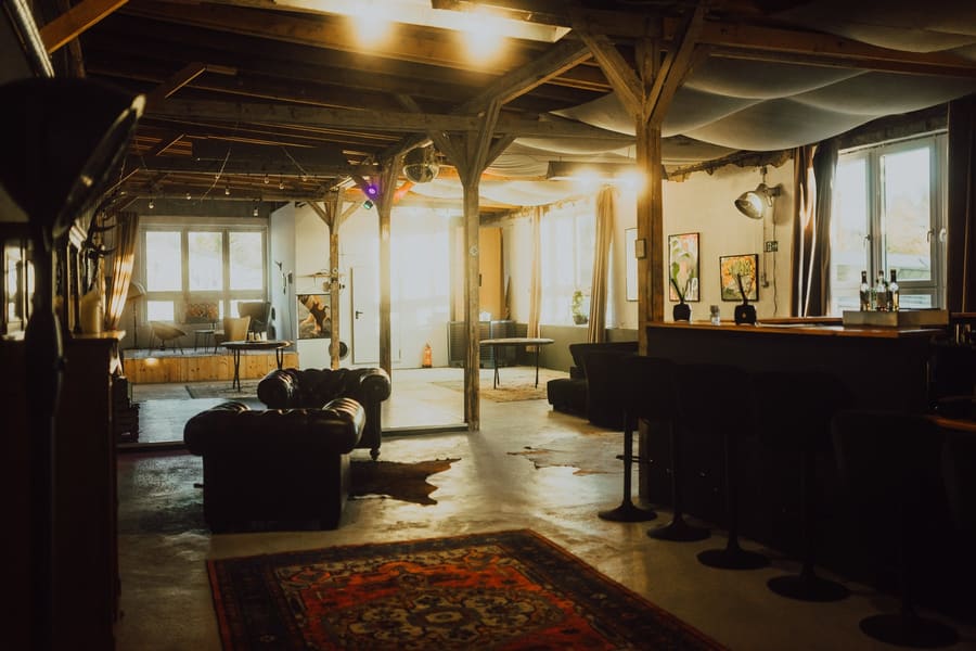 Loft der ZURKRAFT Studios mit Holzbalken und Ledersofas