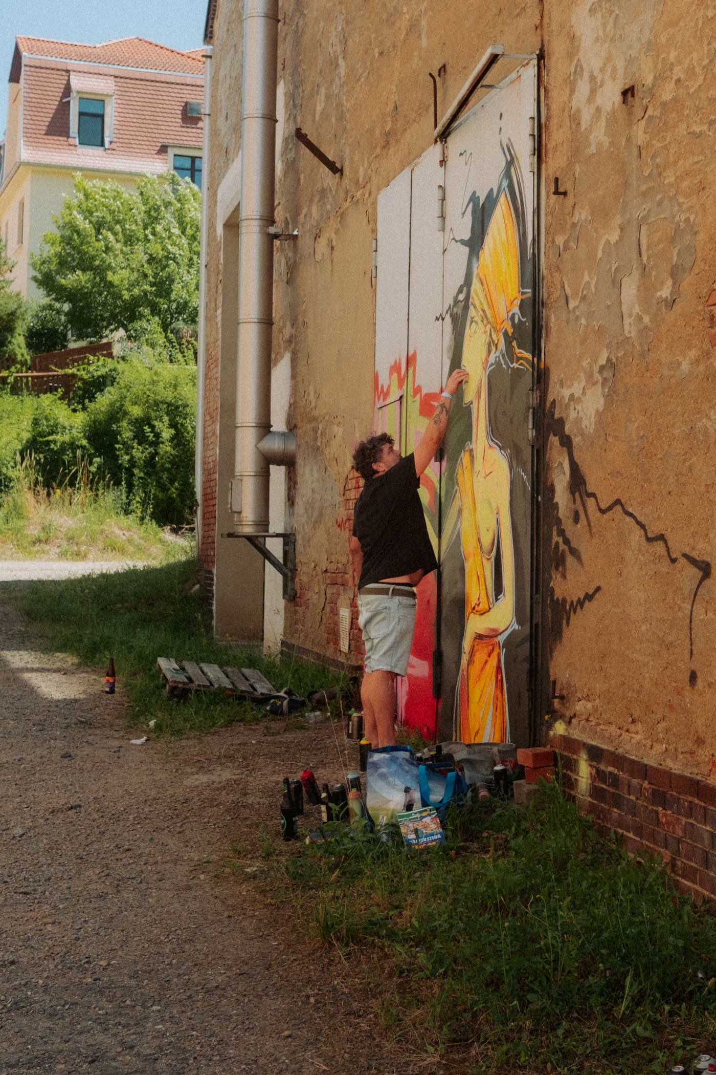 Artist malt ein Wandbild an einer Hausfassade